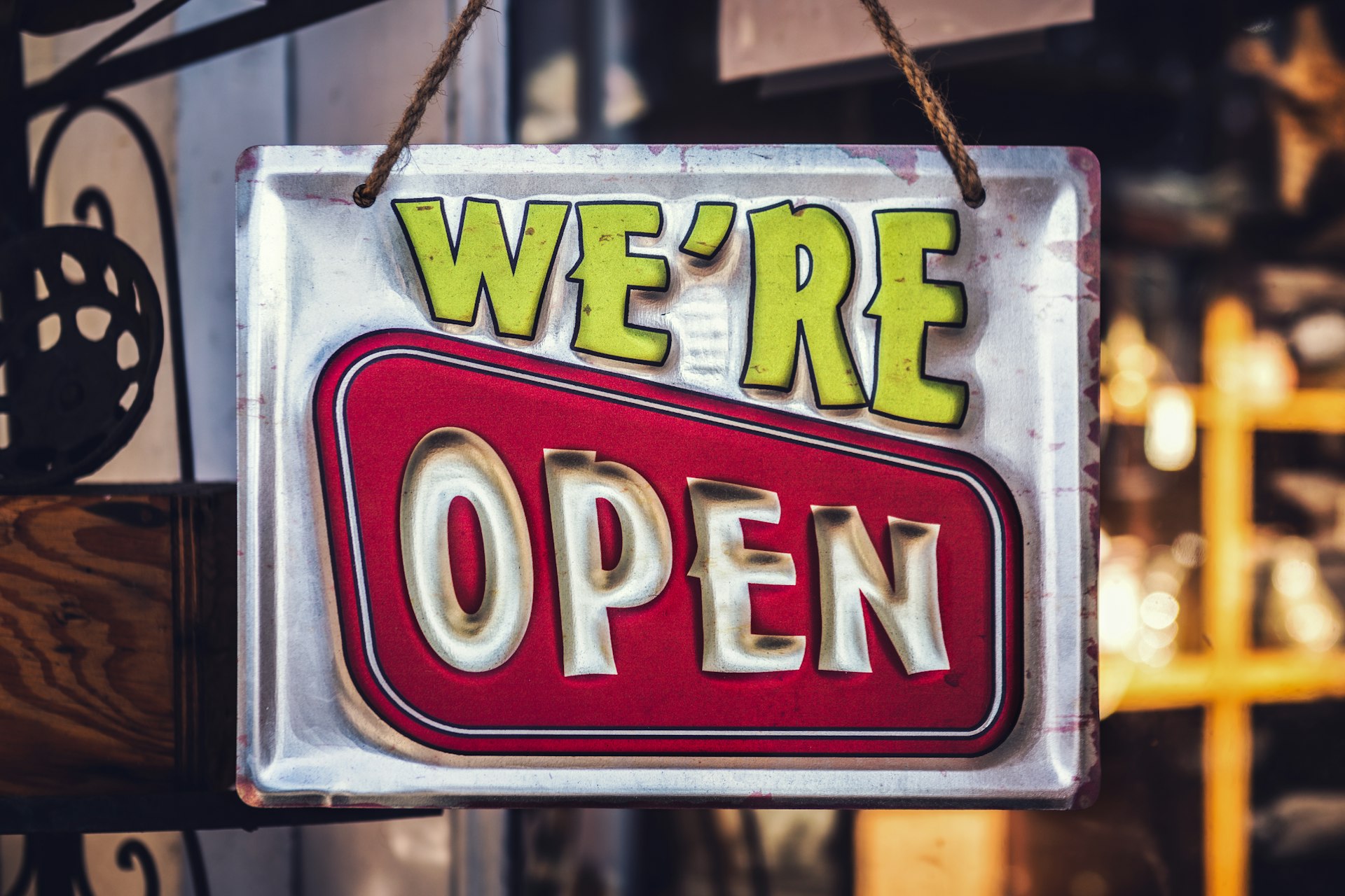 Eye-catching "We're Open" sign showcasing effective retail signage Retro-style "We're Open" sign hanging on a storefront, symbolising inviting retail signage